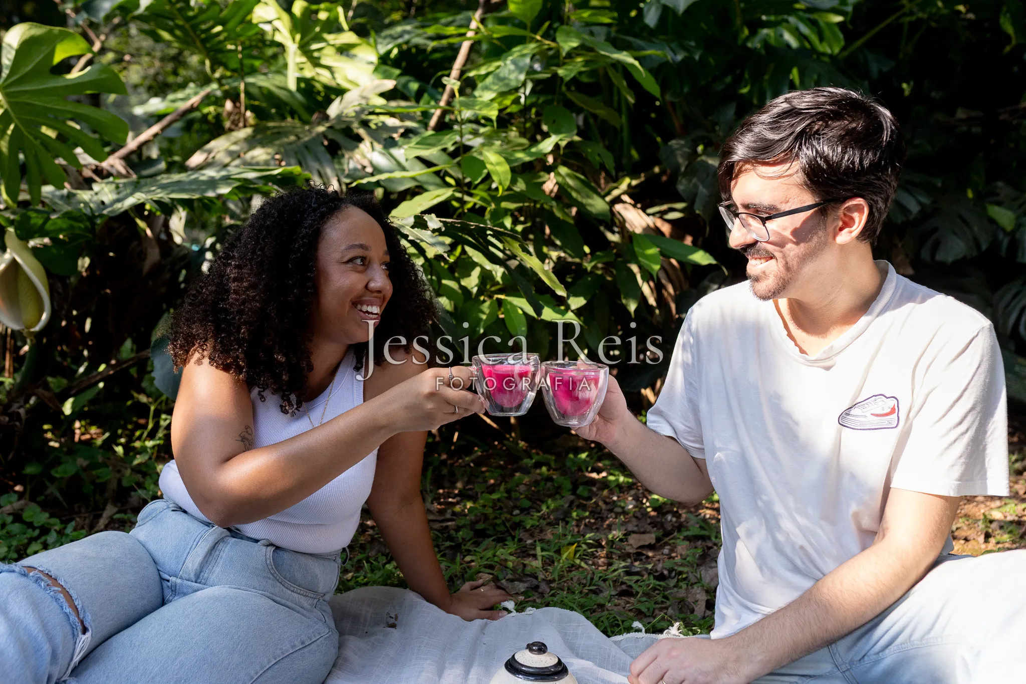 Casal brindando com as taças cor-de-rosa no chá revelação