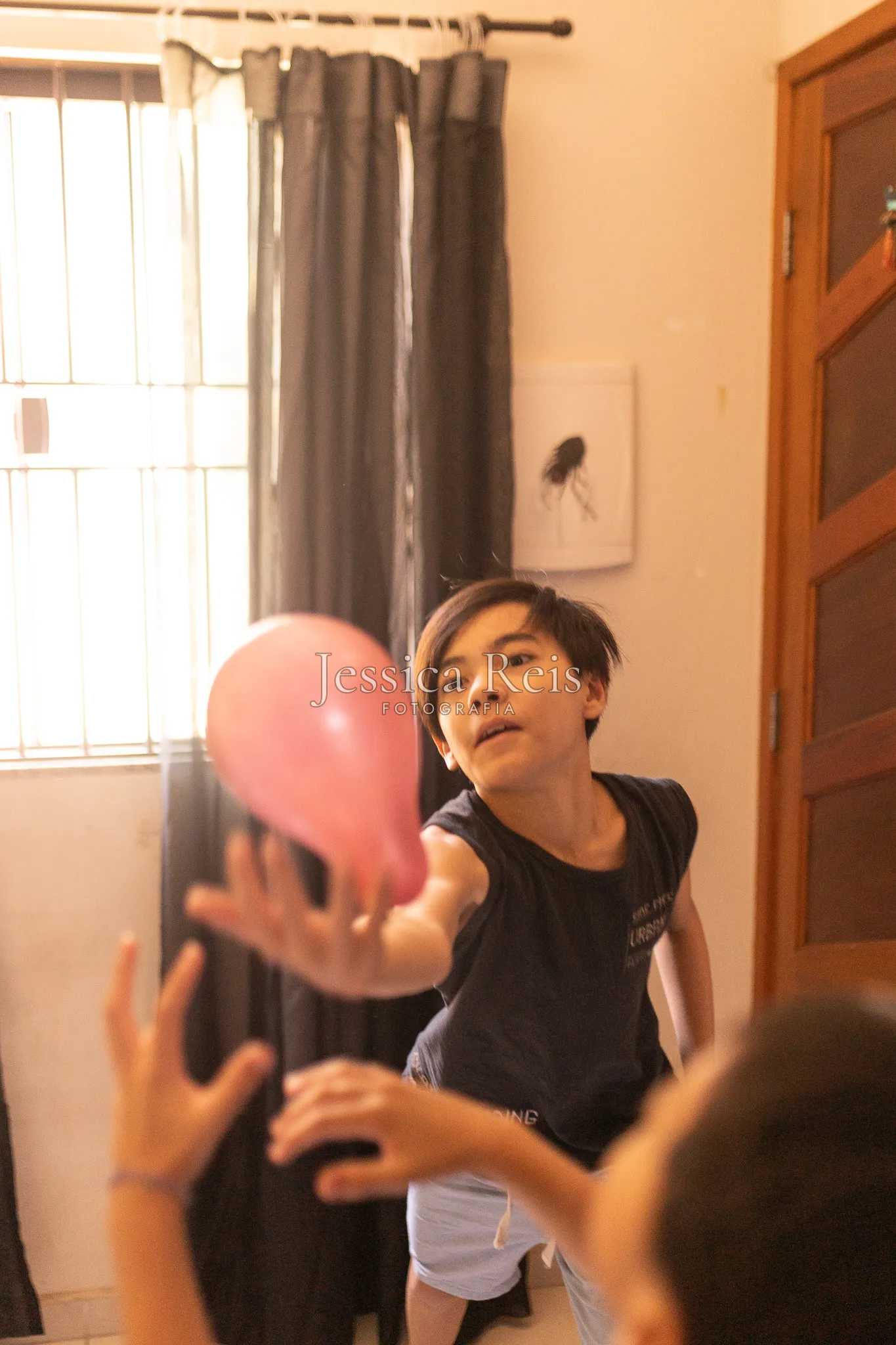 Criança brincando com balão dentro de casa, ensaio de família documental