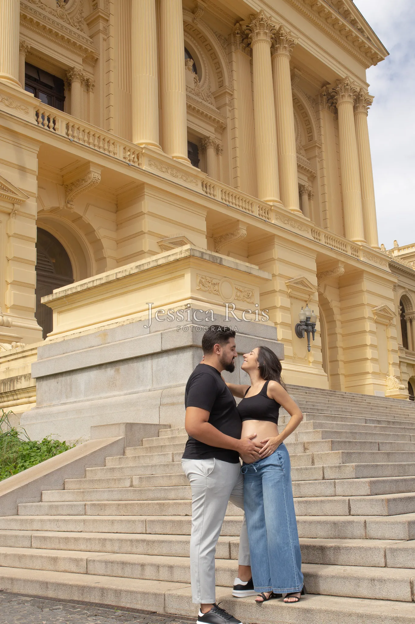 Casal grávido abraçado nas escadarias do Museu do Ipiranga, em São Paulo